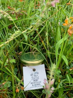 A Jar of Bentley and Sons Soft Set Honey in long grass